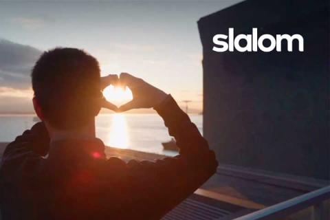 Slalom logo over a man making a heart with his hands in front of the sunset