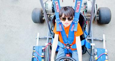 young boy in a gocart, looking up