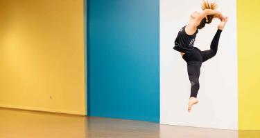 woman dancing in her studio. she is leaping in the air