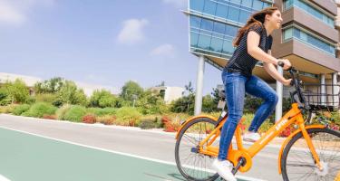 woman riding an ebike on a UC campus