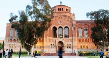 Powell library on the UCLA campus with students walking in front of the building