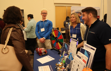 Showcase attendees gather at a supplier table