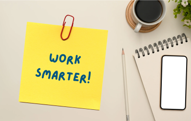 A desktop with a post-it note saying work smarter!