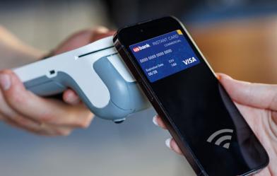A digital credit card on a phone being used to pay for services