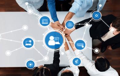 top view of a conference table with everyone touching hands