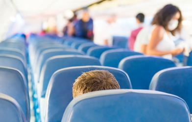 Airline seats with people boarding plane