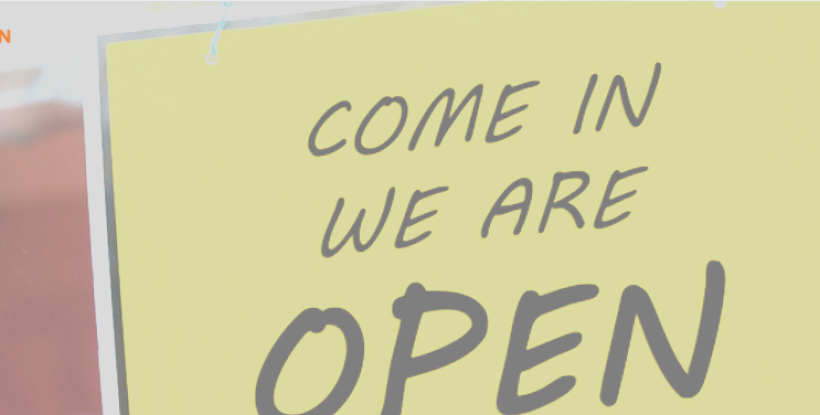 "We are open" sign in a small business window