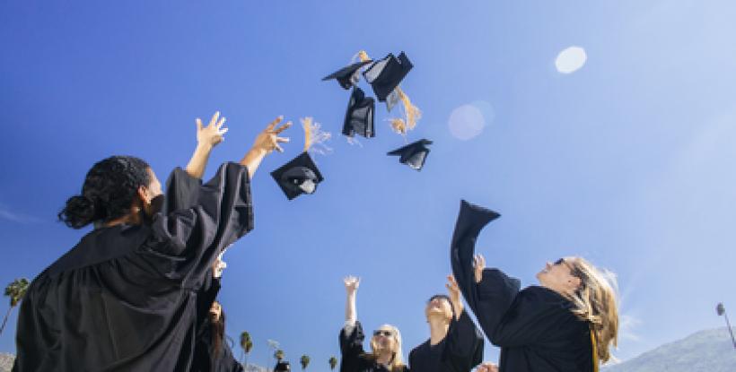 Graduating students tossing caps in the air