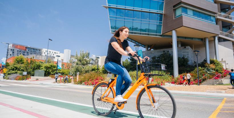 a woman riding an electric bike on campus