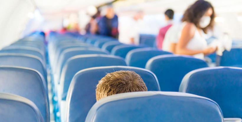 Airline seats with people boarding plane