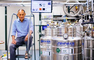 man sitting in front of helium tanks