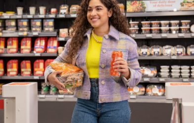 woman leaving a store with her arms full of items