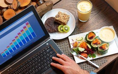 person working on their laptop over breakfast