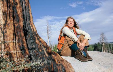 woman sitting on the roots of an ancient tree