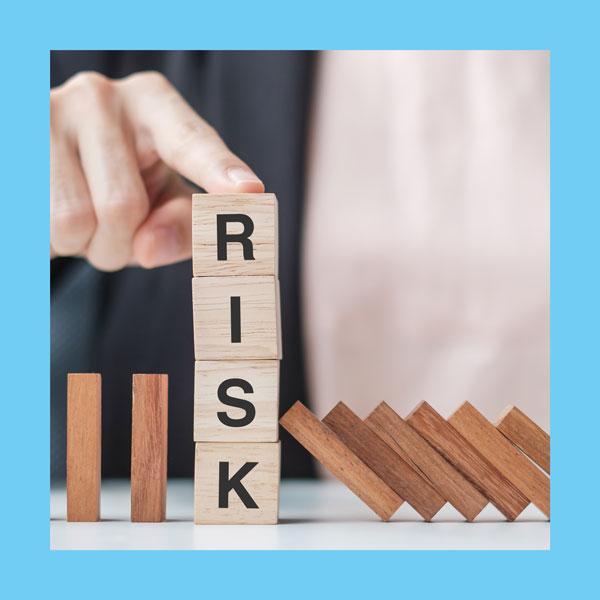 wooden letter blocks stacked to spell the word RISK