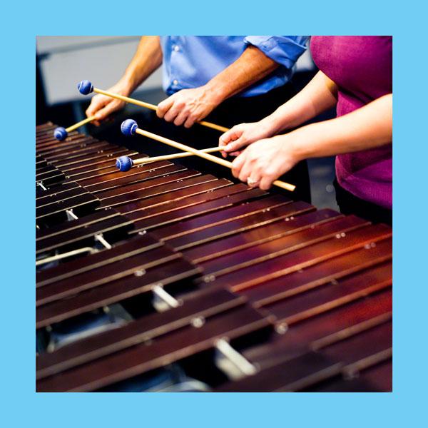 2 people playing a xylophone