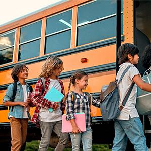 elementary school kids getting on a bus