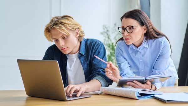 A woman teaching a young man