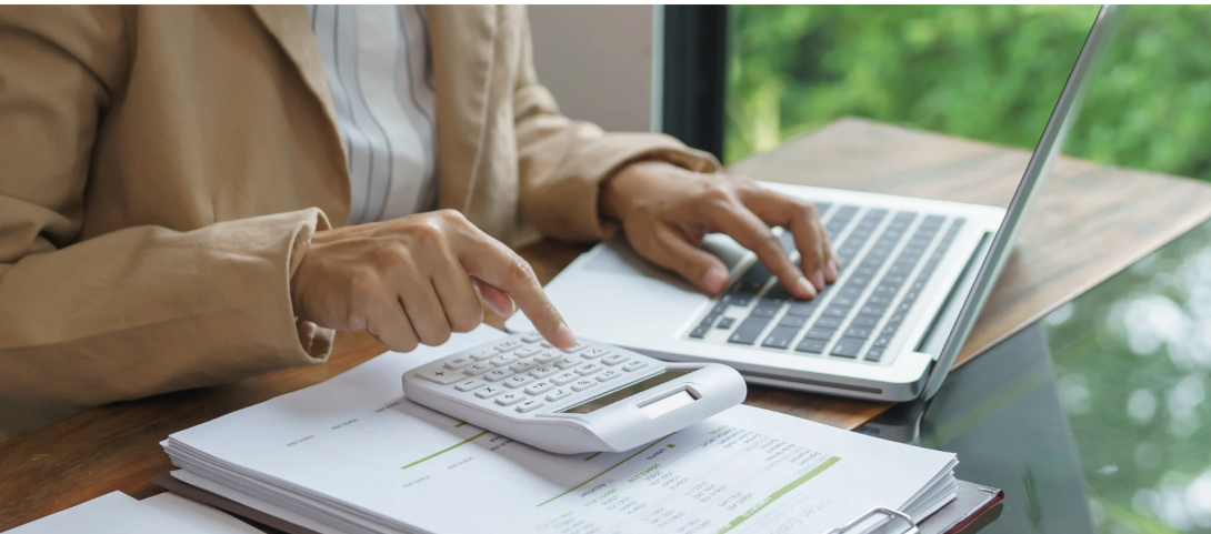 Woman adding up figures with calculator
